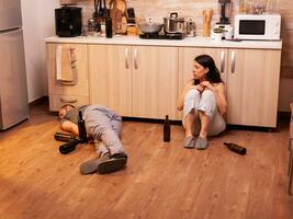 rädd fru efter varelse slagen förbi full Make medan han är sovande på de kök golv. alkoholhaltig aggressiv man missbruka skadar livrädd, rädd, slagen och panik fru. foto