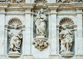 statyer av Jesus, mary och de barn på de Fasad av en byggnad foto