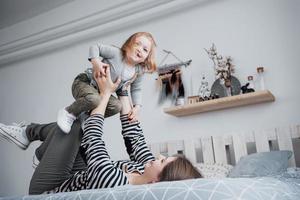 lycklig kärleksfull familj. mamma och hennes dotter barn flicka leker och kramas foto