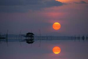 spegel bild av solnedgång på de sjö, thailand. foto
