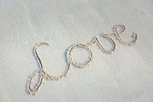 kärlek meddelande skriven i sand. tropisk vit sand, abstrakt teckning och tecken foto