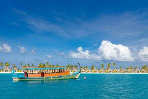 inspirera maldiverna strand design. maldiverna traditionell båt dhoni och perfekt blå hav med lagun bukt. lyx tropisk tillflykt hotell paradis kust. paradis Strand med vit sand, handflatan träd foto
