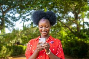 skön afrikansk lady leende handla om Vad hon fick syn på på henne smart telefon foto