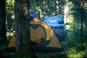 tält med SUV -bil i skogen foto