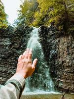 kvinna hand vattenfall på bakgrunden foto