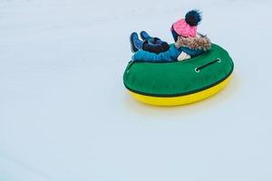 människor som åker snöslangar på vinterparken foto