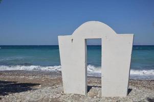 en båge som står på stenkusten vid Egeiska havet i byn theologos i Rhodos, Grekland