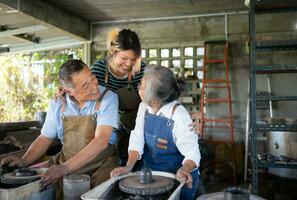 porträtt av en senior asiatisk par håller på med aktiviteter tillsammans i de krukmakeri verkstad. foto