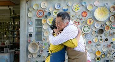 i de krukmakeri verkstad, ett asiatisk pensionerad par är engagerad i krukmakeri framställning och lera målning aktiviteter. foto