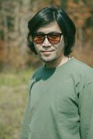 porträtt av lång hiar asiatisk man med leende ansikte stående utomhus- foto