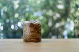glas av mjuk dryck med iced på trä tabell. foto