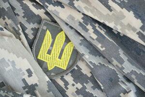 symbol av ukrainska armén på de kamouflage enhetlig av en ukrainska soldat. de begrepp av krig i Ukraina, patriotism och skyddande din Land från ockupanter foto