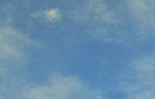 en blå molnig himmel med många små moln blockering de Sol foto
