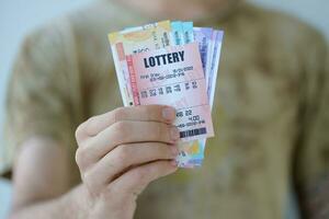 man händer med indisk rupier räkningar och lotteri biljett. begrepp av hasardspel och vinnande pengar i indisk lotteri foto