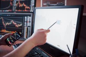 analysera data. närbild av ung affärsman som pekar på data som presenteras i diagrammet med penna medan han arbetar på kreativa kontor
