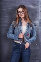 mode, kläder, människor koncept. attraktiv sexig ung kvinna med jeansjacka. flicka poserar i studion