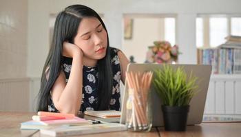 en universitetsstudentkvinna satt och blundade medan hon studerade online hemma. foto