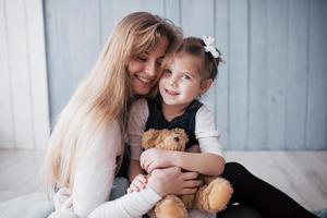 lycklig kärleksfull familj. mamma och hennes dotter barn flicka leker och kramas foto