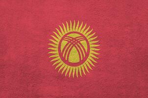 kyrgyzstan flagga avbildad i ljus måla färger på gammal lättnad putsning vägg. texturerad baner på grov bakgrund foto