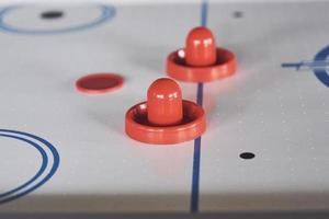 airhockeybord med fönsterbelysning och röd leksakshockeypinne foto