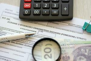 deklaration av de belopp av tjänade inkomst eller uppkommit förlust grop-36l beskatta former på revisor tabell med penna och putsa zloty pengar räkningar foto