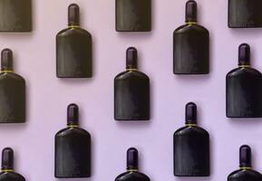 mörk lila parfym flaska med gyllene band på pastell papper bakgrund. trendig doft foto