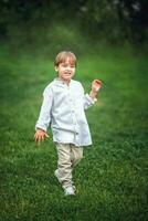 en ung stilig pojke av europeisk utseende åtnjuter utgifterna tid på de grön gräsmatta på Hem. dess en bra tid till koppla av. foto