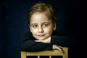en koncis porträtt av en europeisk pojke. porträtt på en mörk bakgrund. foto