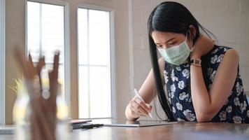 asiatiska kvinnor arbetar hemma för att förhindra spridning av koronarviruset, eller covid-19.