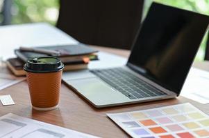 beskuren bild av en applikationsdesigners skrivbord med en mobil skärmskiss och ta bort kaffe på hemmakontoret. foto