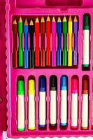 en rosa fall med många färgad pennor och markörer foto