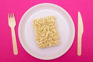 okokt omedelbar spaghetti på vit tallrik. rå pasta. torr asiatisk snabb mat. snabbt lunch foto