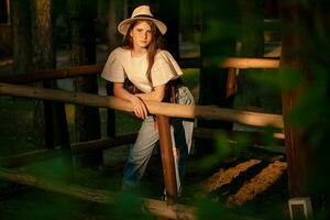 Tonårs flicka stående i Land egendom i skog i strålar av miljö sommar Sol foto