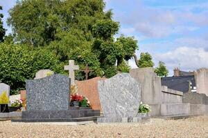 en kyrkogård med många gravstenar och träd foto