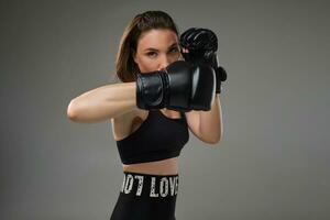 atletisk kvinna i boxning handskar är praktiserande karate i studio. foto