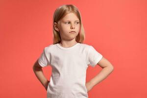 närbild studio skott av en trevlig blond liten flicka i en vit t-shirt Framställ mot en rosa bakgrund. foto