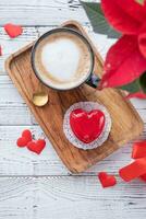hjärta formad glaserad valentine kaka i säng på trä- bricka foto