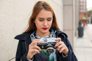 porträtt av en Söt ung turist tar fotografier med årgång retro kamera foto