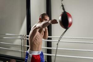 en boxare bär handskar i de Träning hall. boxare sparka i de Gym. foto