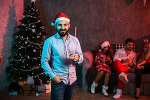 jul, jul, ny år, vinter, lycka begrepp - leende man i santa hjälpare hatt med en glas av champagne foto