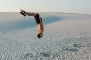 man studie parkour på deras egen. akrobatik i de sand foto