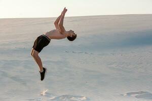 man studie parkour på deras egen. akrobatik i de sand foto