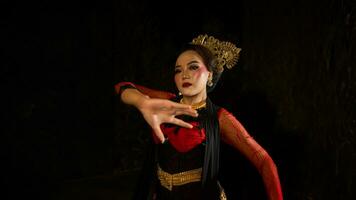 ett indonesiska dansare söker ut och inviterar de publik till vara genom bort i en kulturell prestanda foto