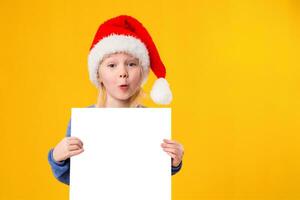 söt liten flicka i santa claus hatt med en vit tom papper ark. jul, jul, ny år, vinter, människor, annons, försäljning begrepp. foto
