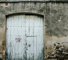 gammal stängd tyg dörr med järn beslag. medeltida trä- dörr i en sten vägg. t foto