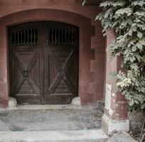 en medeltida stängd bakgård dörr i en sten vägg. typisk arkitektur av Europa. utsmyckad medeltida dörröppning i barcelona foto