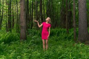 skön flicka fångad i de sommar regn medan gående i de skog foto