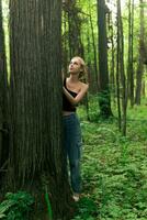 flicka tonåring i en lövfällande lund kommunicerar med träd foto