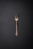 kök gaffel tillverkad av stål på en mörk texturerad bakgrund foto