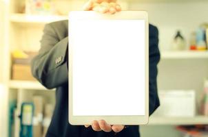 affärsman som håller en tom vit pekskärmstablett. används för att lägga text eller information för att annonsera nyheter eller sälja produkter online. koncept marknadsföring foto